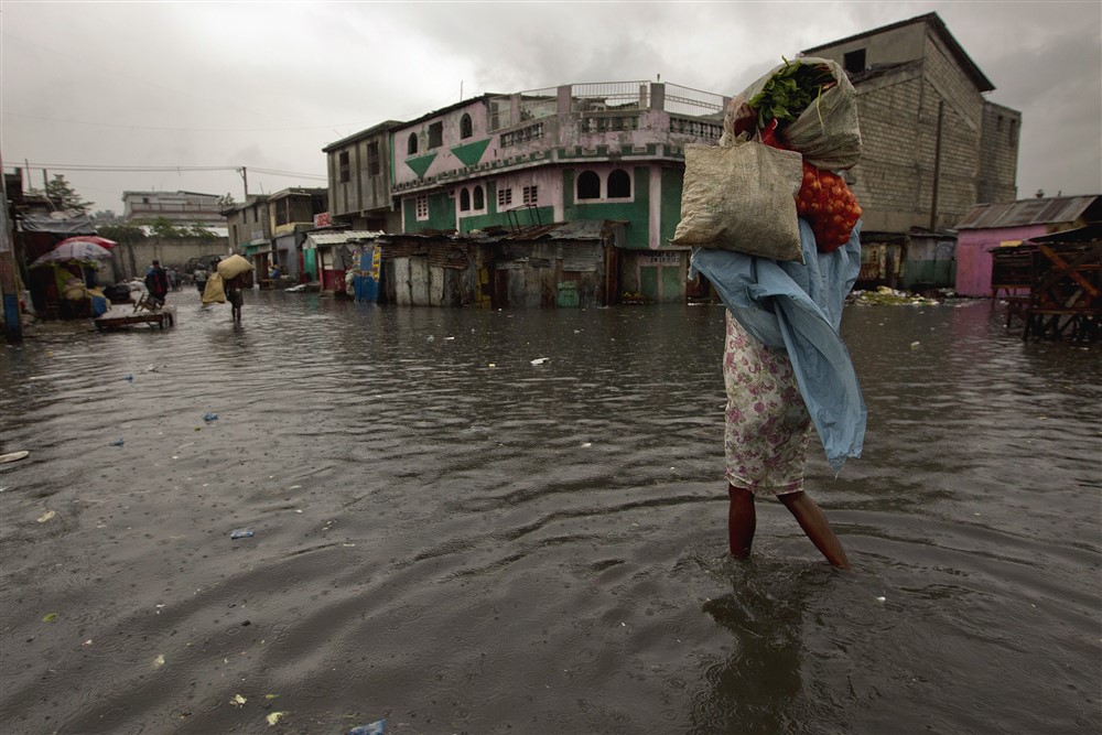 A woman walks through a flooded market in Port au Prince. Hurricane Sandy passed to the west of Haiti October 25, 2012 causing heavy rains and winds, flooding homes and overflowing rivers. Photo Logan Abassi UN/MINUSTAH